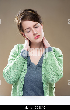 Magnifique jeune femme brune présentant des symptômes de la douleur au cou. Banque D'Images