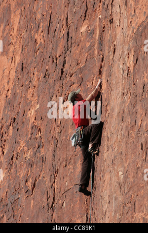 Man in red rock escalade une falaise de grès rouge à Red Rocks, Nevada Banque D'Images