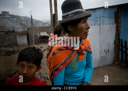 Une famille se tient à l'extérieur de leur petite cabane à Lima, Pérou, Amérique du Sud. Banque D'Images