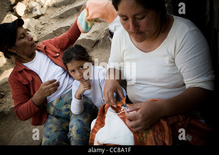 Les femmes pulls tricotés dans un bidonville de Lima, Pérou, Amérique du Sud. Banque D'Images