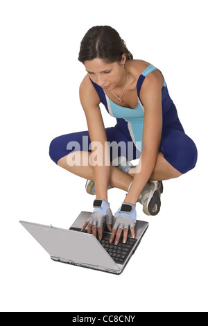 Femme dans l'équipement de formation à la recherche de quelque chose sur un ordinateur portable. Banque D'Images