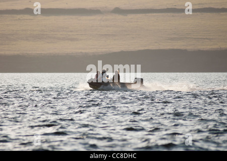 Petit bateau gonflable sur l'accélération de l'eau contre le soleil Banque D'Images