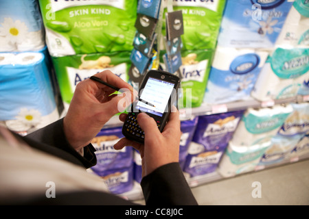 Un ordinateur de poche faisant une vérification en magasin sur les produits en vente Banque D'Images