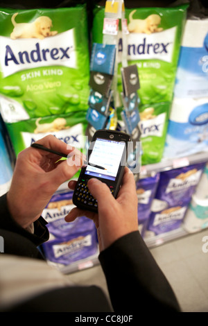 Un ordinateur de poche faisant une vérification en magasin sur les produits en vente Banque D'Images