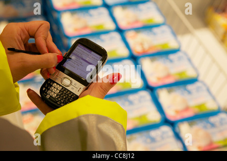 Un ordinateur de poche faisant une vérification en magasin sur les produits en vente Banque D'Images