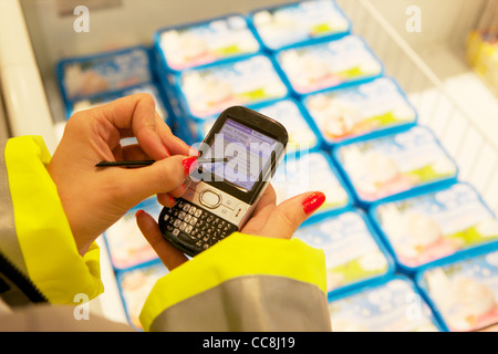 Un ordinateur de poche faisant une vérification en magasin sur les produits en vente Banque D'Images