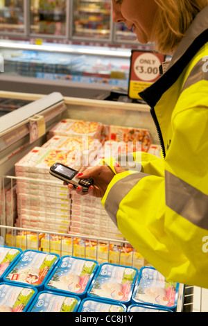 Un ordinateur de poche faisant une vérification en magasin sur les produits en vente Banque D'Images