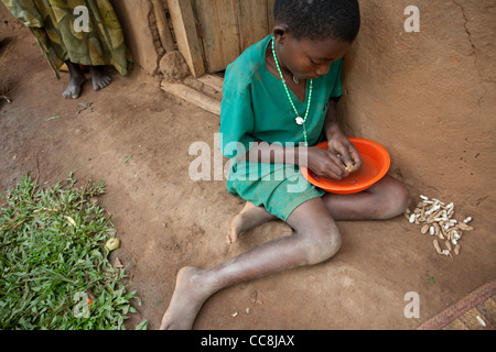 Un enfant à l'extérieur de sa coquille d'arachides et de la boue de l'herbe accueil à Masaka, en Ouganda, en Afrique de l'Est. Banque D'Images