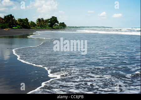 Marée de la mer sur la plage de sable noir. Bali, Indonésie Banque D'Images