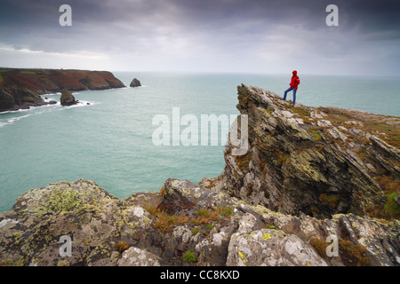 Un marcheur se tenait sur la pointe à Boscastle à Cornwall, UK, en direction ouest le long de la côte vers Tintagel. Banque D'Images