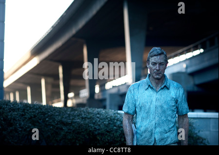 Le Westway fliyover dans l'ouest de Londres avec une sculpture d'un homme marchant dans l'avant-plan sculpteur britannique Sean Henry Walking Man Banque D'Images
