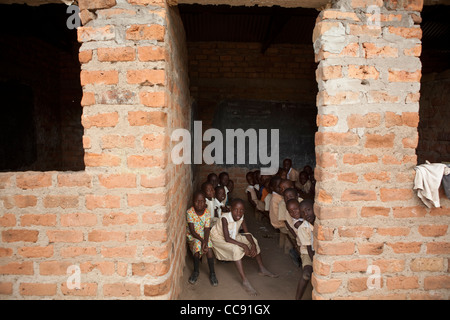 Les élèves s'asseoir dans un petit, sombre dans la salle de classe, l'Ouganda Amuria, Afrique de l'Est. Banque D'Images