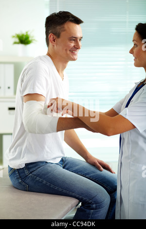 Portrait de jolie femme médecin de l'administration des premiers soins au patient à l'hôpital Banque D'Images