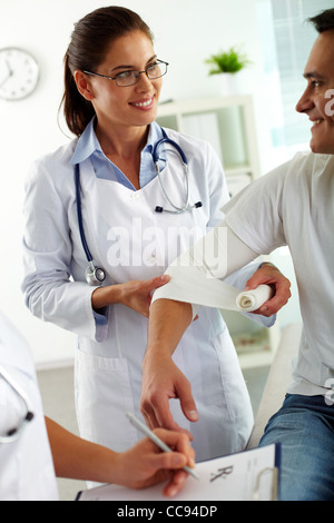 Portrait de jolie femme médecin de l'administration des premiers soins au patient à l'hôpital Banque D'Images