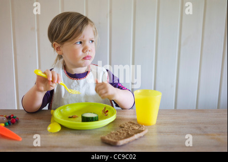 Young Girl Eating at Table, Suède Banque D'Images