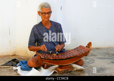 Un musicien joue du xylophone à l'intérieur d'un temple de la Sri Satchanalai Historical Park. La province de Sukhothai, Thaïlande. Banque D'Images