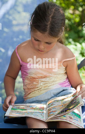 Petite fille lecture bande dessinée. Banque D'Images