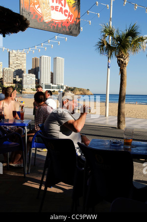 Les touristes anglais de boire de la bière au bar de plage de Playa Levante, Benidorm, Costa Blanca, Espagne Banque D'Images