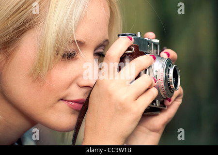 Belle jeune fille pour prendre des photos avec un appareil photo vintage ancien Banque D'Images