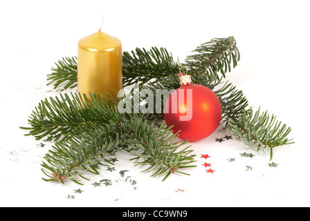 Sapin de noël avec des rameaux, une boule de noël et une bougie jaune Banque D'Images