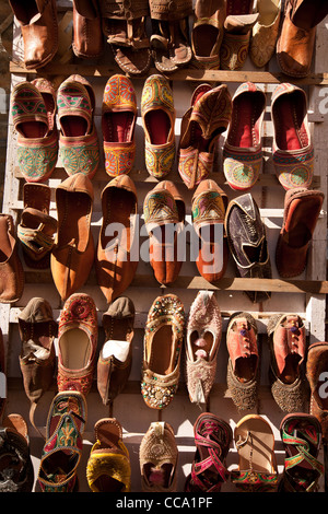Chaussures en cuir et des chaussons en vente comme souvenirs sur un mur à l'intérieur de Fort de Jaisalmer, dans le Rajasthan, Inde. Banque D'Images