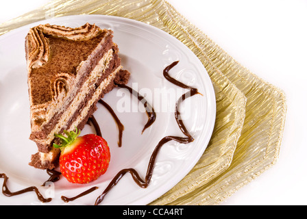 Gâteau tiramisu aux fraises sur la plaque avec une serviette sur l'or Banque D'Images