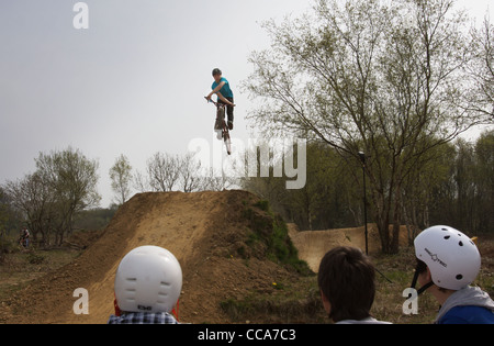 Un bmxer équitation grand sauts saleté de Swansea, Pays de Galles du Sud vu à par des amis Banque D'Images