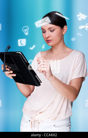 Une femme d'affaires avec des icônes d'affaires flottant autour de sa tête. Portrait de jolie femme travaillant avec son tablet pc Banque D'Images