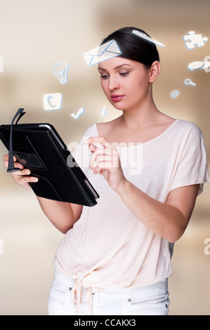 Une femme d'affaires avec des icônes d'affaires flottant autour de sa tête. Portrait de jolie femme travaillant avec son tablet pc Banque D'Images