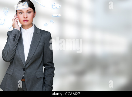 Une femme d'affaires avec des icônes d'affaires voler autour de sa tête. Portrait de jolie femme travaillant avec son téléphone à la recherche à Banque D'Images