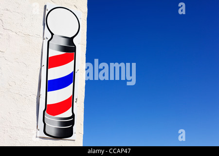 Une boutique de coiffeur signe sur un mur blanc. Banque D'Images