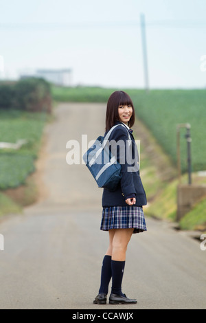 Female High School Student Standing on Rural Road Banque D'Images