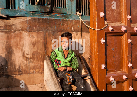 Garçon assis en face de Rangaji mandir, Vrindavan, Inde Banque D'Images