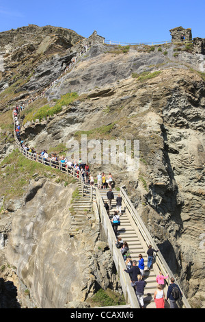 Hoildaymakers sur la côte nord des Cornouailles à Tintagel sur un jour d'été escalade la falaise côté à King Arthurs Castle Banque D'Images