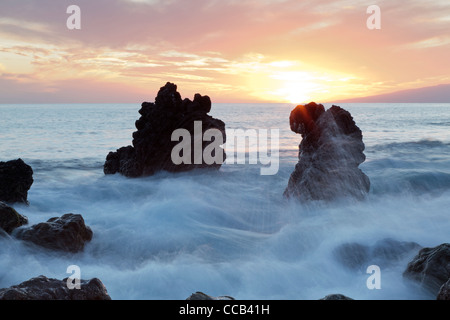 Mer brisant autour des roches au coucher du soleil sur la côte ouest de Tenerife, Canaries, Espagne Banque D'Images