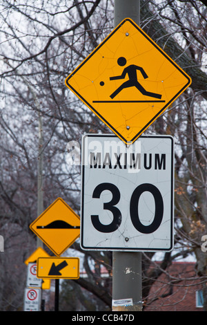 Une aire de jeux pour signer, en haut d'une limite de vitesse à 30km/h Inscrivez-vous dans l'arrière-plan sont les signes d'un parking et d'arbres Banque D'Images