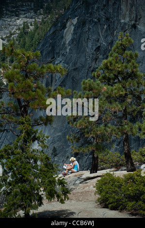 Un jeune couple assis et reposant sur le granit en haut de Nevada Falls. Le Parc National Yosemite. La Californie. USA Banque D'Images