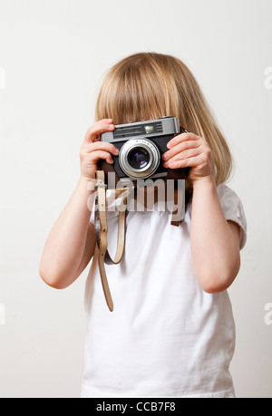 Petite fille avec un vieil appareil photo. Studio shot. Banque D'Images