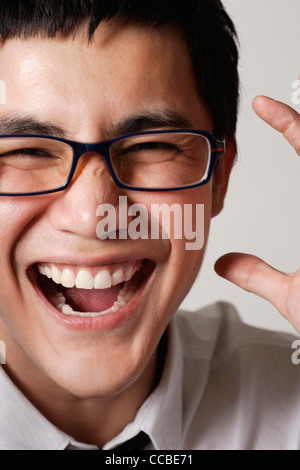 Close up of young man wearing glasses and laughing Banque D'Images