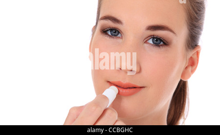 Jeune femme attrayante à l'aide de baume de lèvre. Le tout sur fond blanc. Banque D'Images