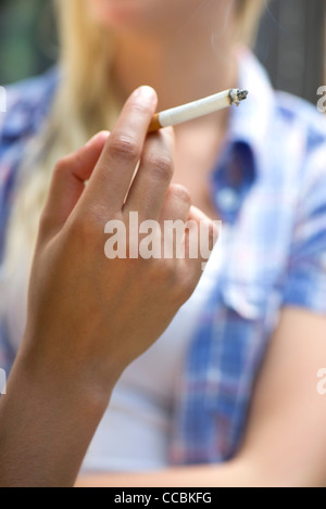 Woman's hand holding cigarette allumée Banque D'Images