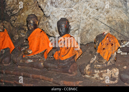 Statues anciennes dans une grotte à Khao Chong Phran pleine de cafards venant à se nourrir sur les MTD gauno habitant dans la grotte. Banque D'Images