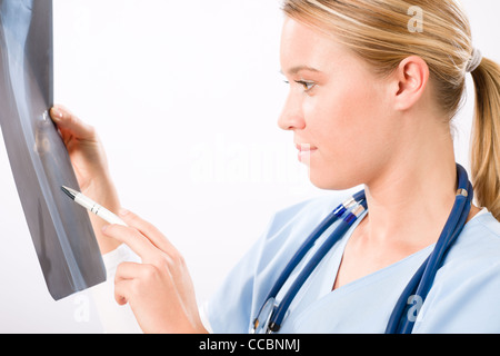 Young female doctor examining x-ray isolé sur fond blanc Banque D'Images