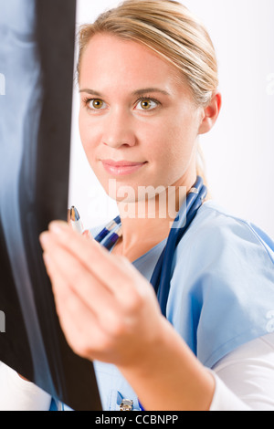 Young female doctor examining x-ray isolé sur fond blanc Banque D'Images