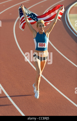 Femme en marche sur la voie avec le drapeau américain Banque D'Images