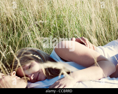 Sieste couple ensemble dans l'herbe haute Banque D'Images