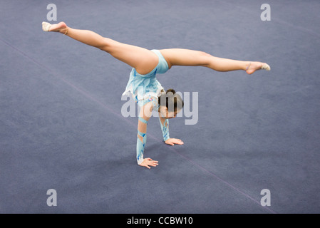 Femme gymnast performing handstand Banque D'Images