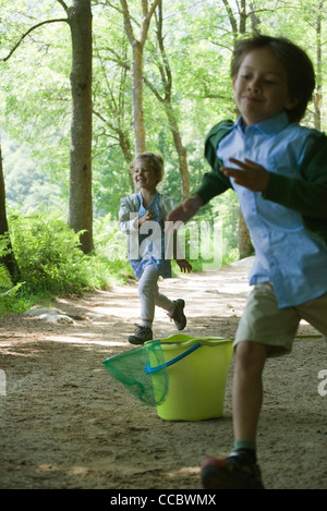 Les enfants courent dans les bois Banque D'Images