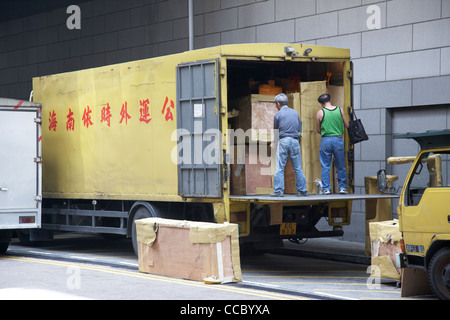 Les hommes de déchargement chargement de caisses d'emballage de l'arrière d'un camion van plateau élévateur de Hong Kong Hong Kong Chine Asie Banque D'Images