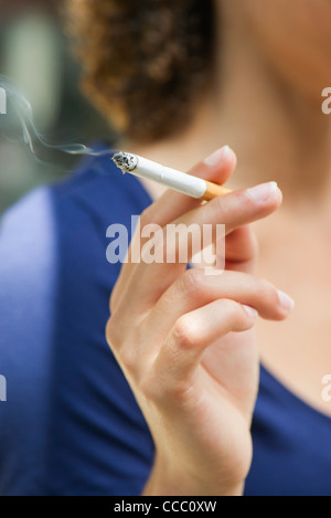 Woman's hand holding cigarette allumée Banque D'Images